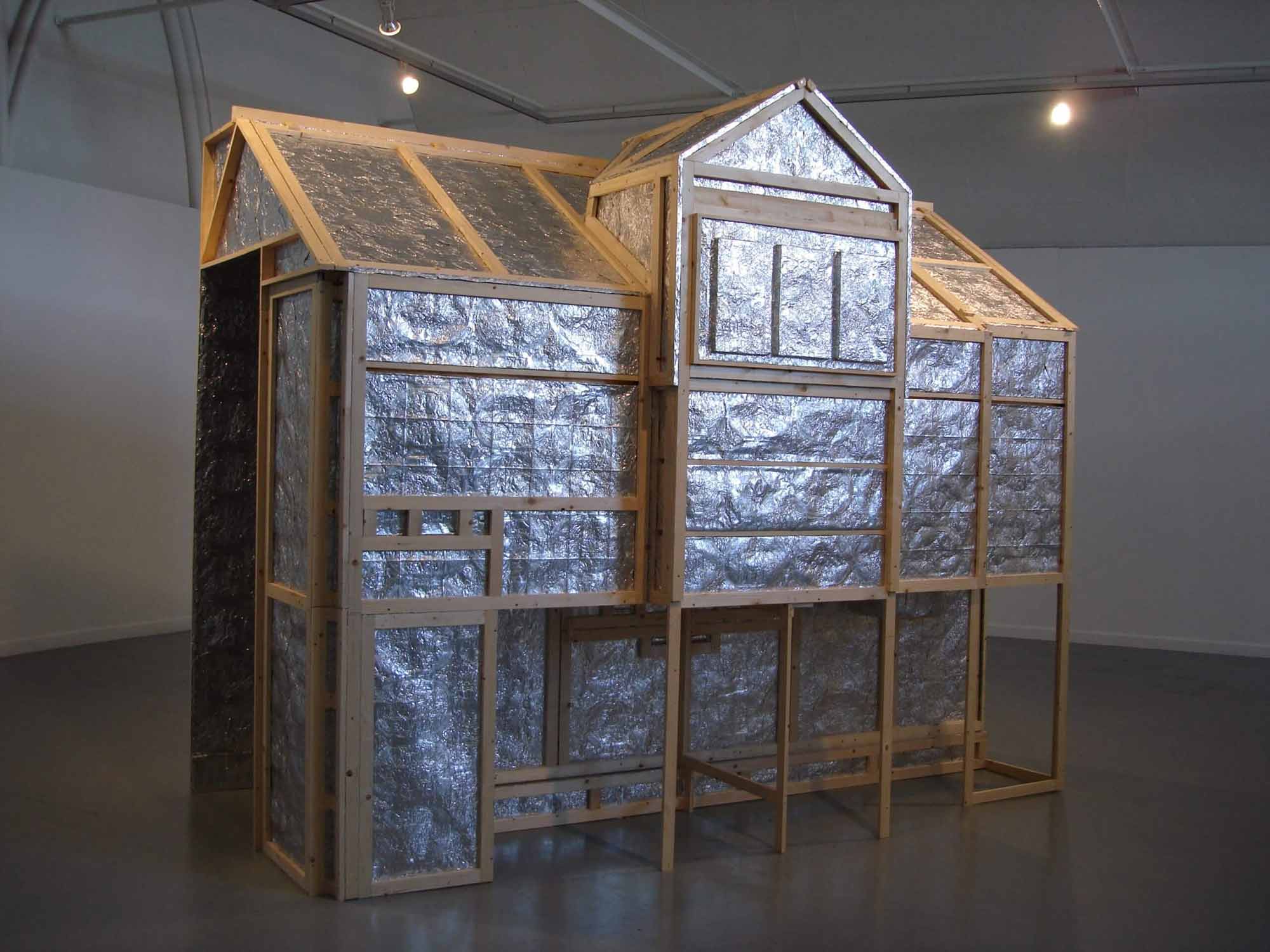 Interior photograph of an installation structure made of wood and silver foil.