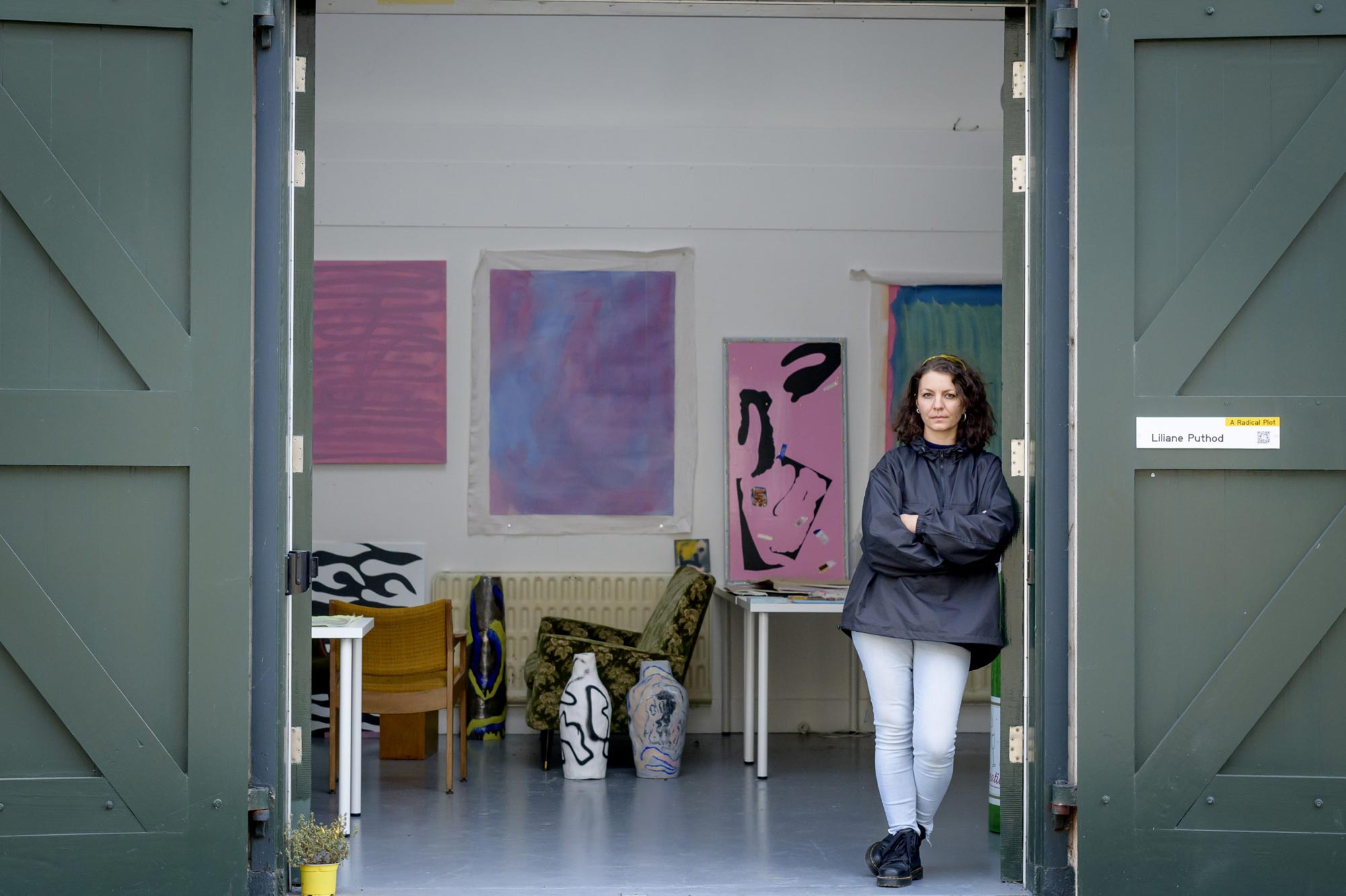 Photo of artist Liliane Puthod in the open doorway of their studio